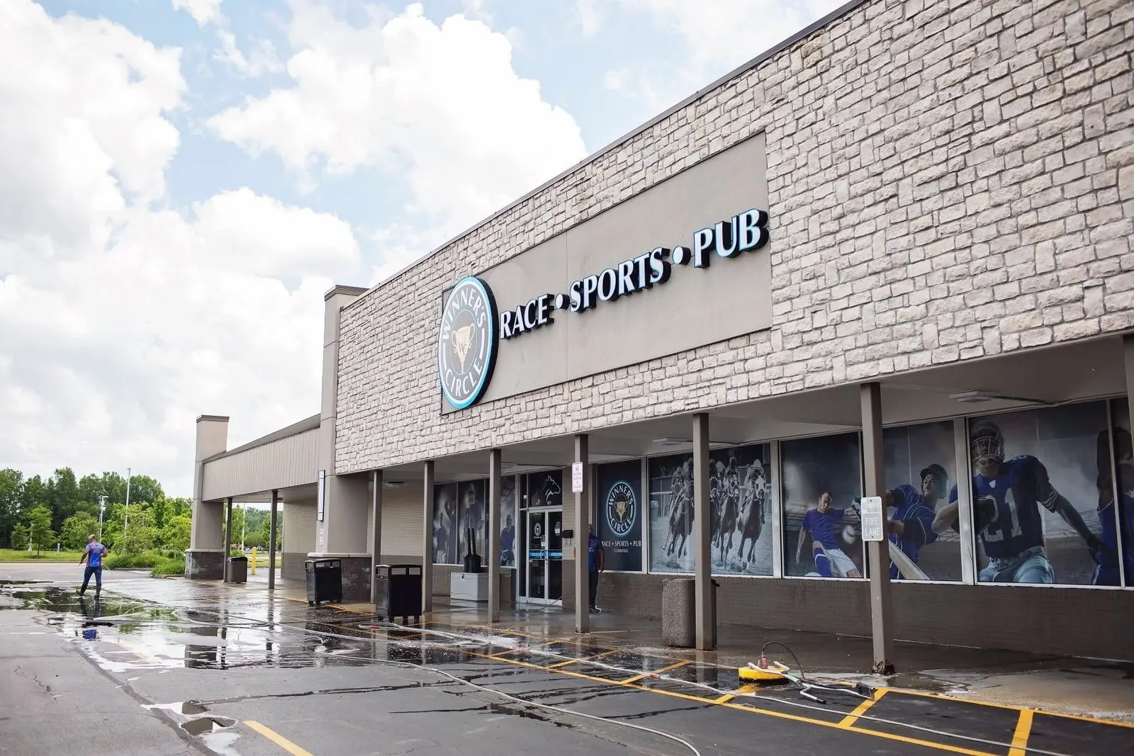 Washing the parking area in front of a sports pub storefront