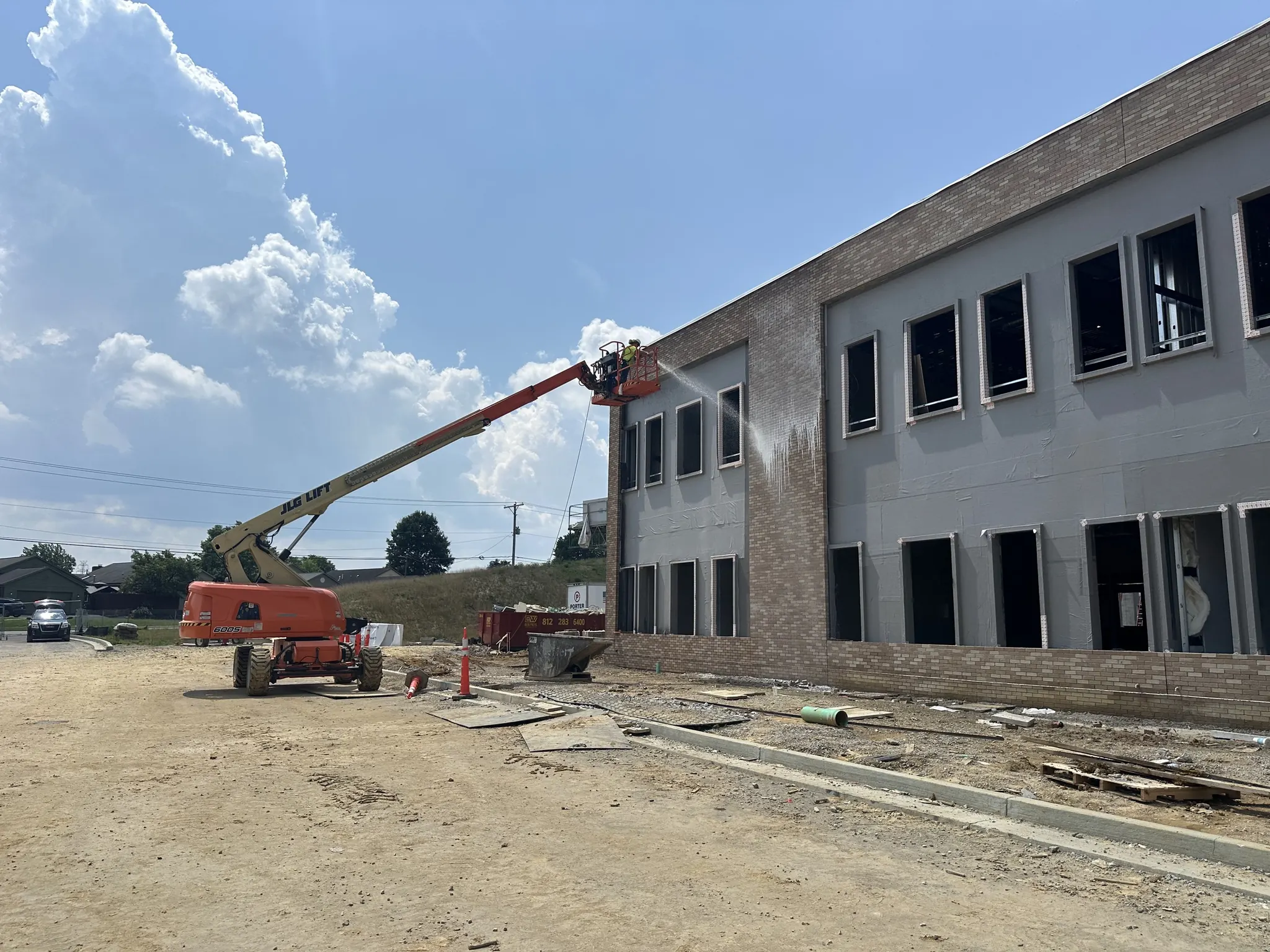 Boom lift washing the facade of a new commercial building