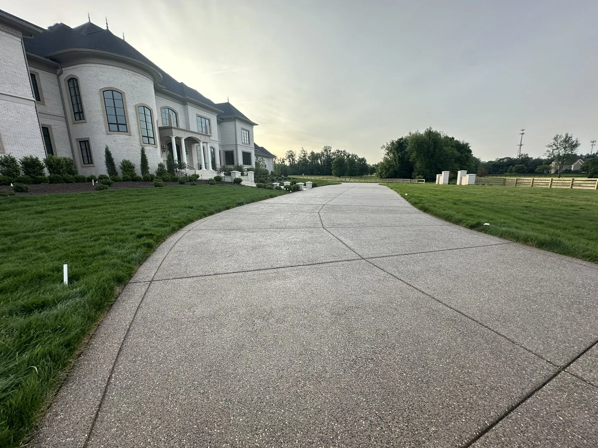 Exposed-aggregate concrete driveway running between two lawns