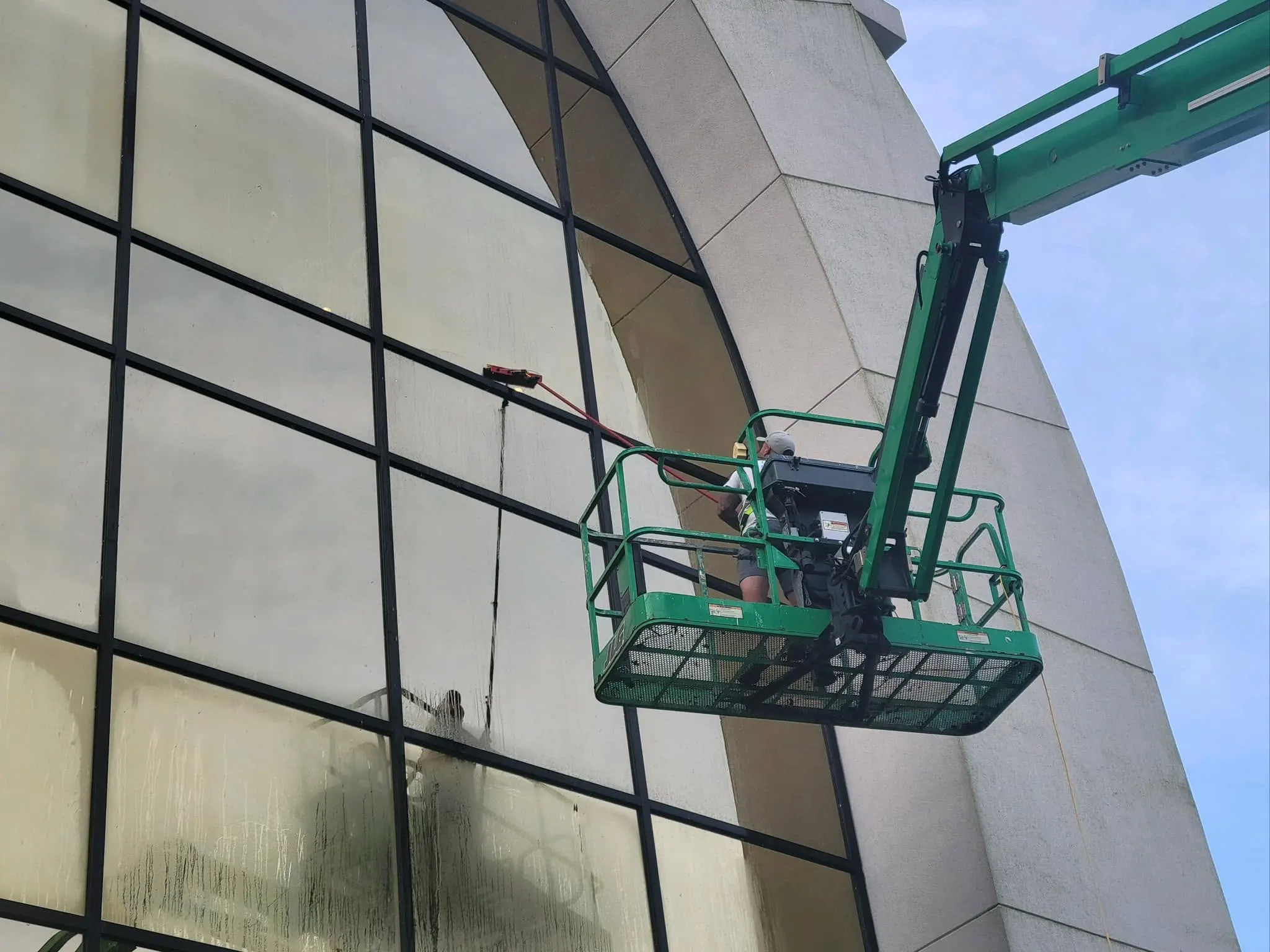 Lift basket beside a tall arched glass facade