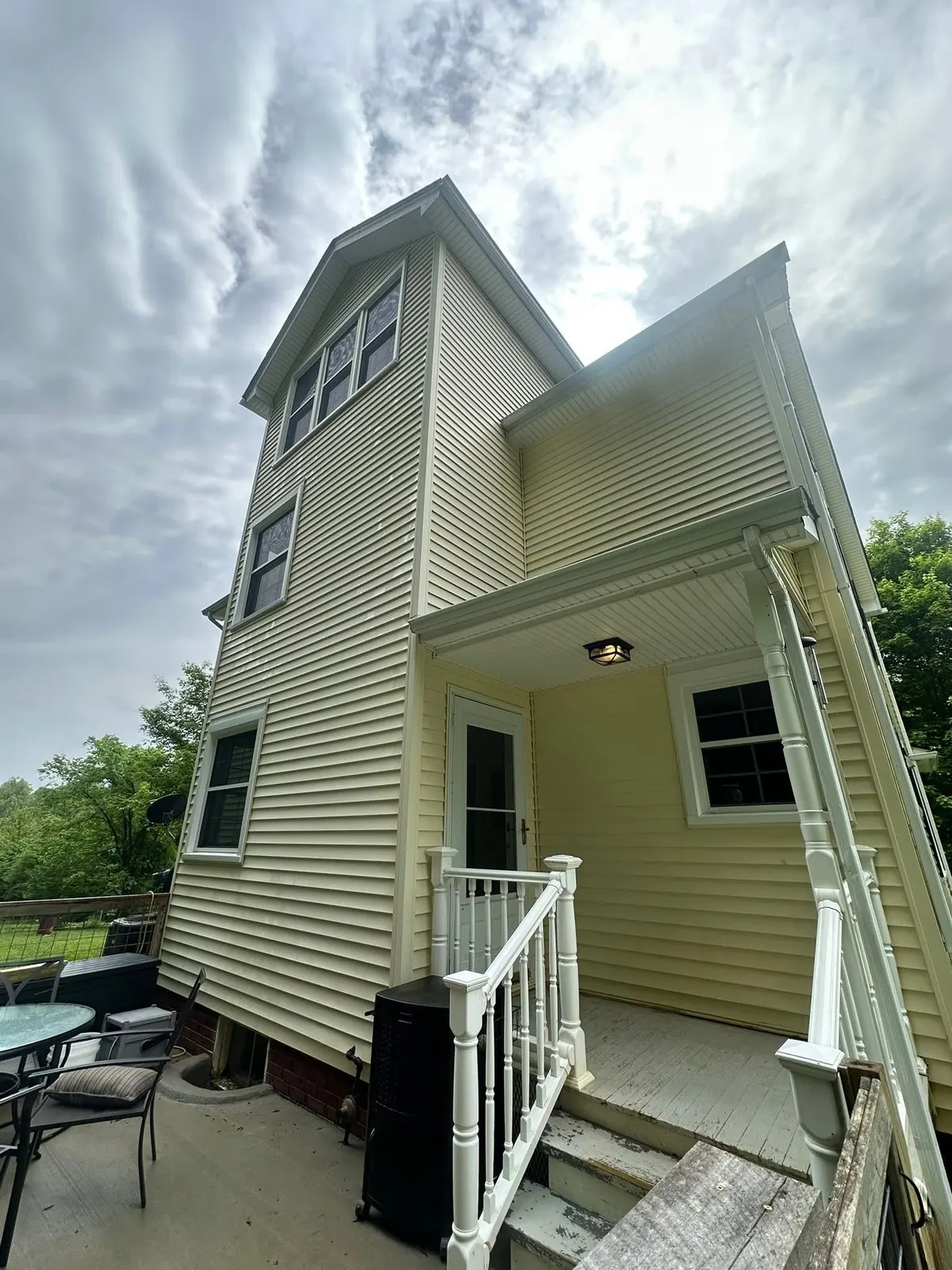 Clean yellow siding on the back of a house after washing