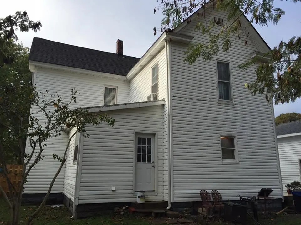 The same white house with clean siding after washing