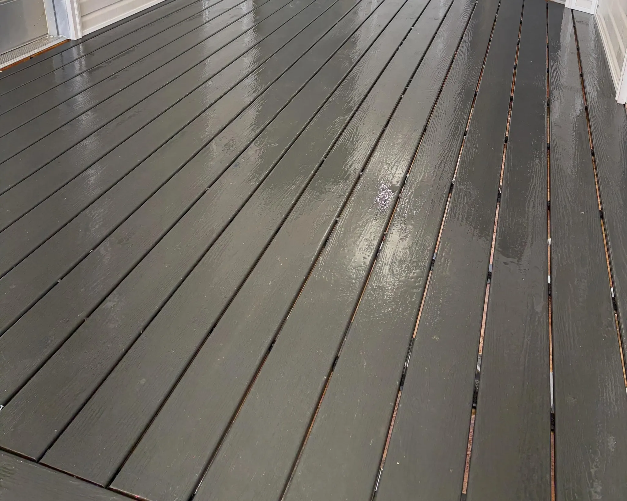 Wood deck boards with an even dark gray finish after restoration