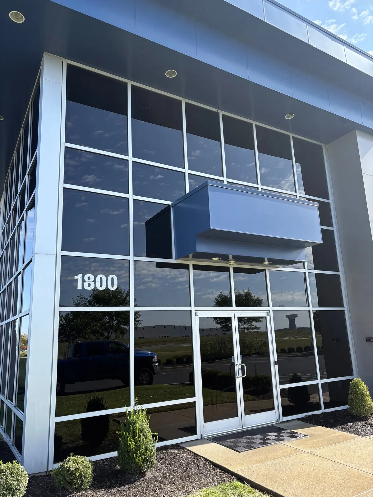 Glass entrance and window wall of a two-story office building