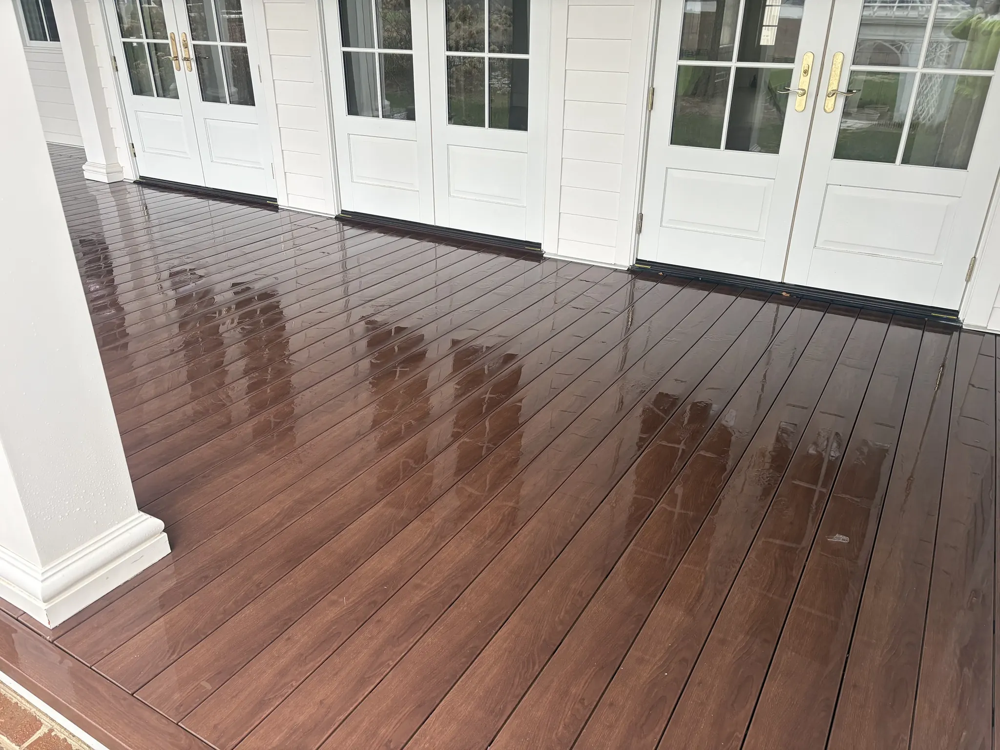 Freshly cleaned wooden porch deck in front of French doors
