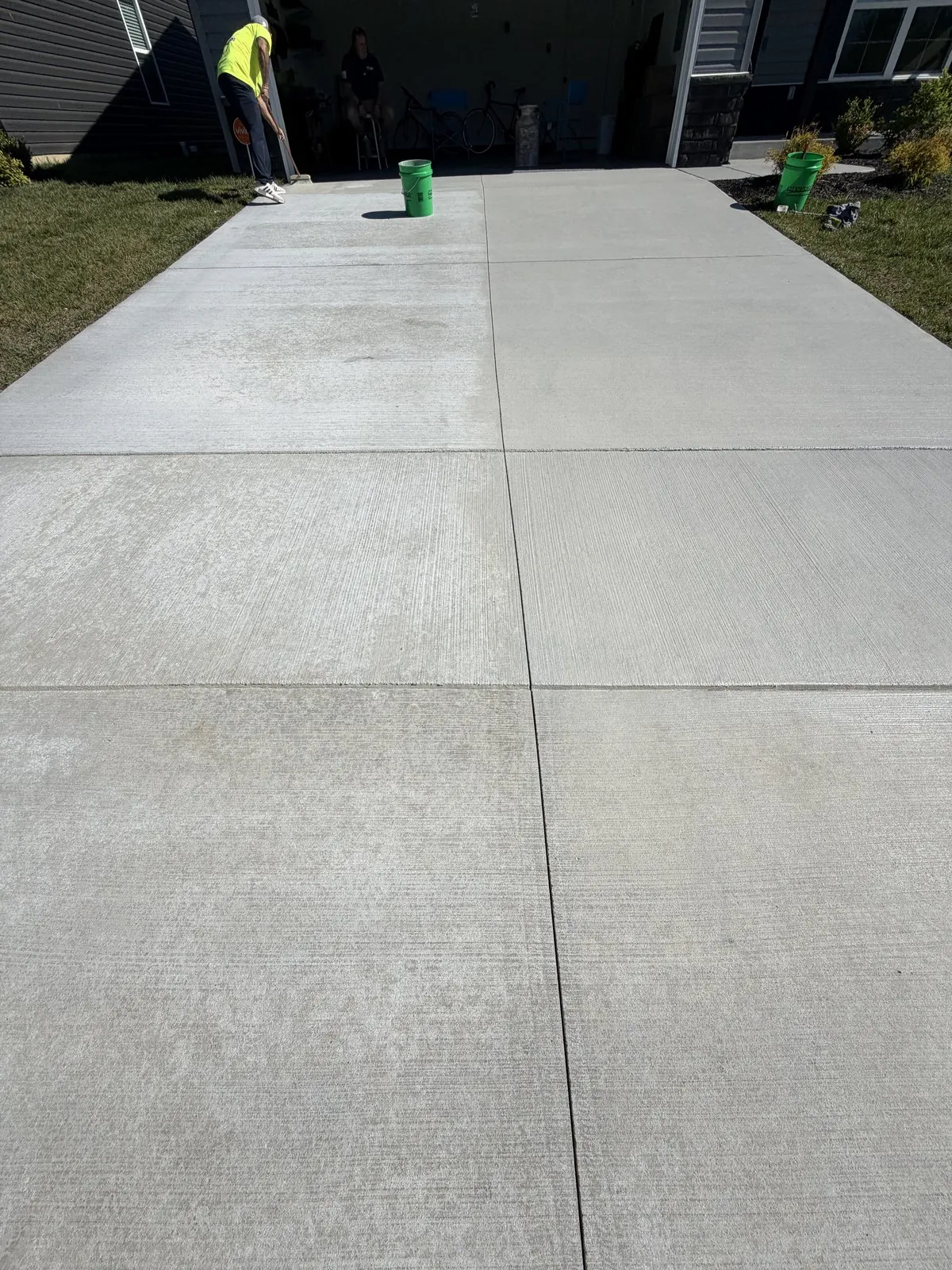 Long new concrete driveway beside a lawn
