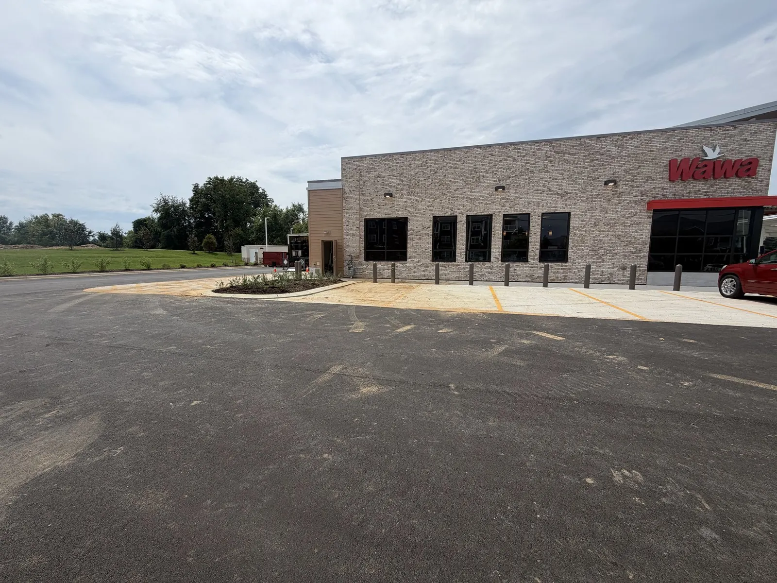 New brick convenience store beside a freshly paved parking lot