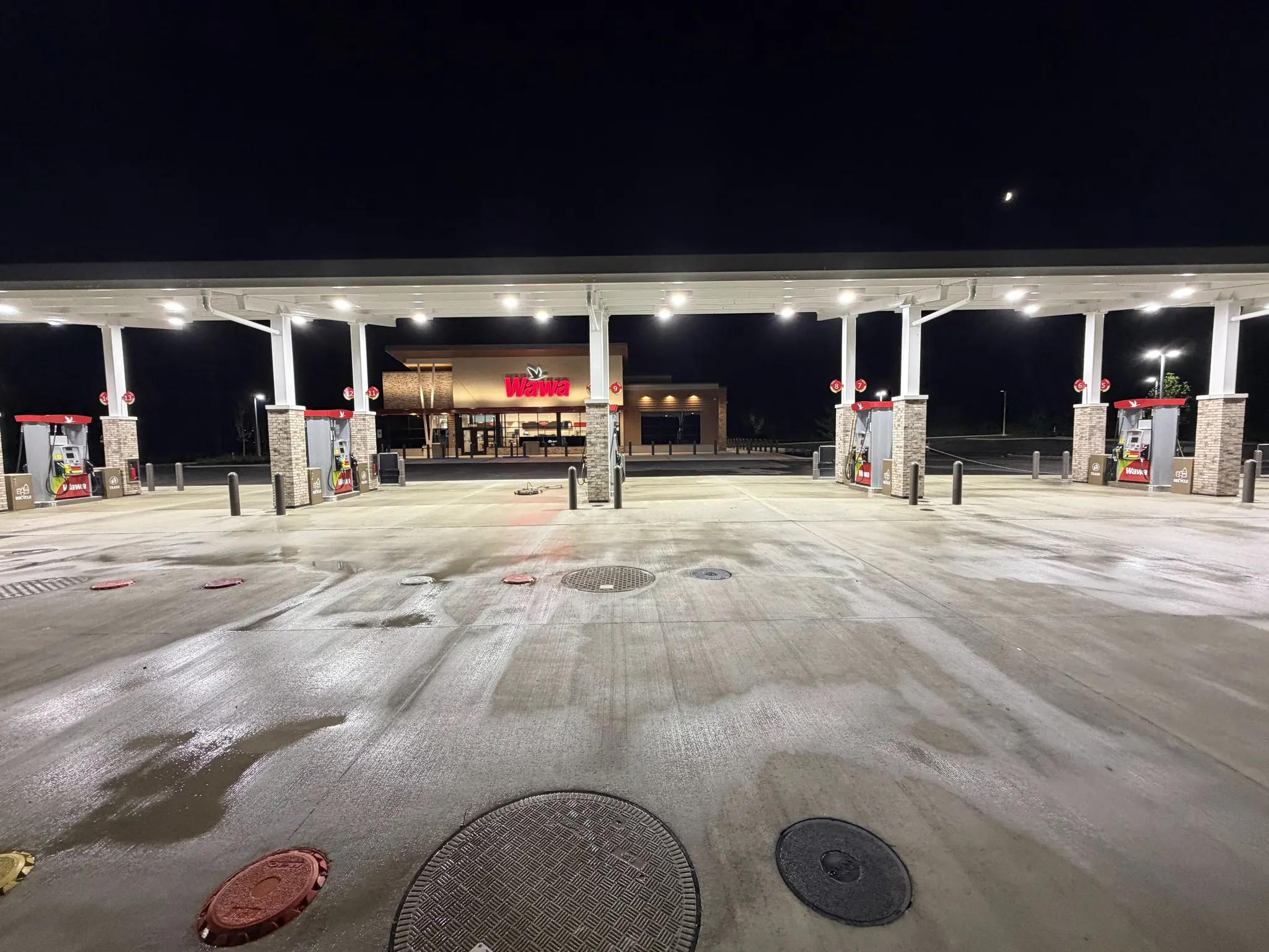 Fuel-station forecourt being cleaned at night