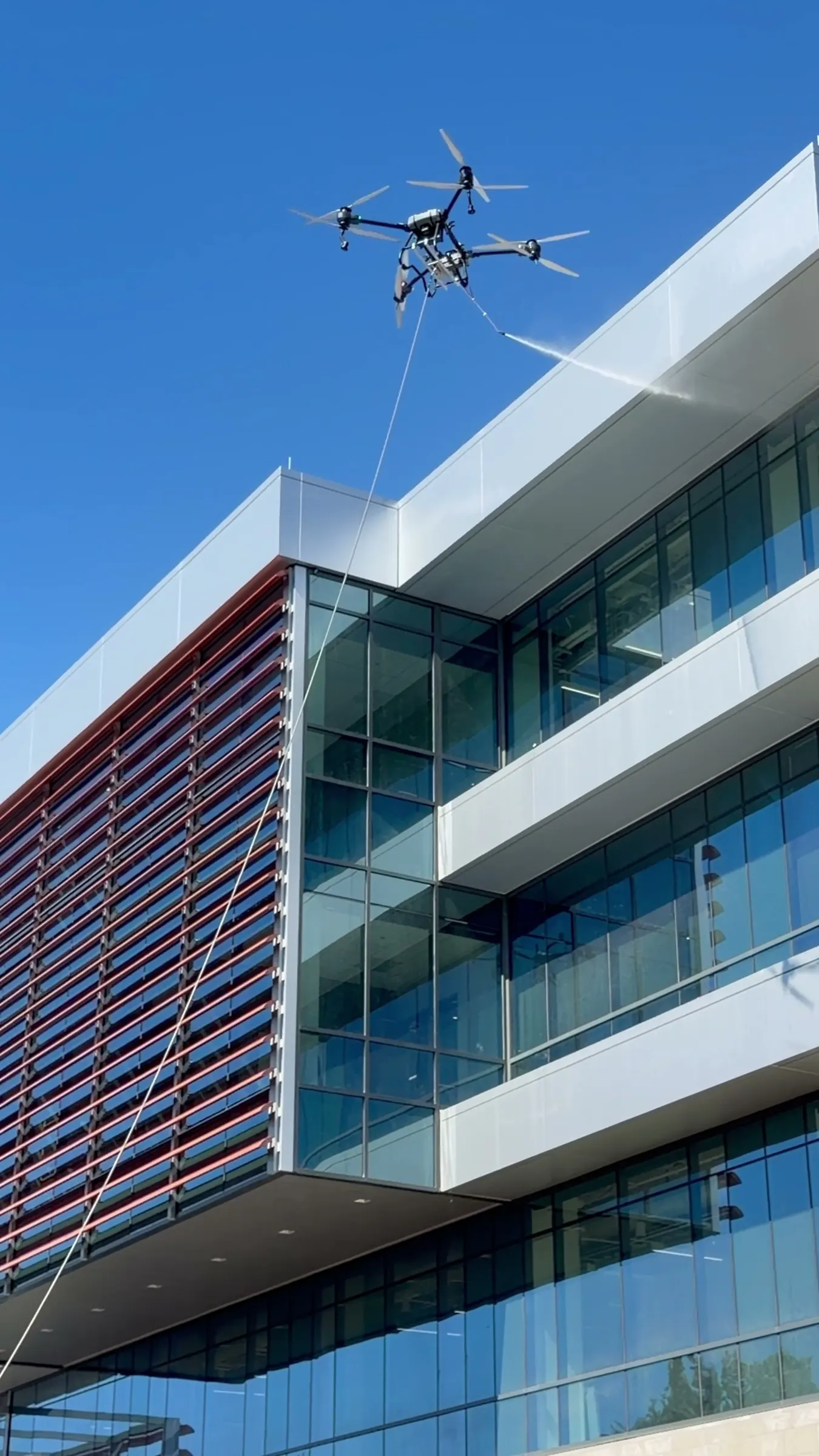 Drone washing the upper facade of a modern office building